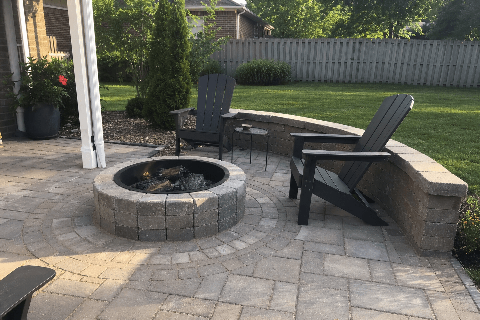 Finished paver patio with circular fire pit and seating.