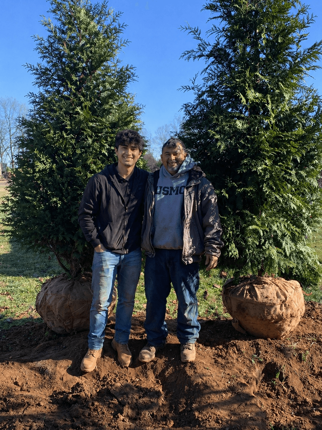 Father and son team from Orlando's Landscaping standing together on a landscaping job site.